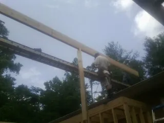 Carpenter setting a ridge beam over a new addition frame — Ice Dam Removal by Roofing Brothers in Cambridge City