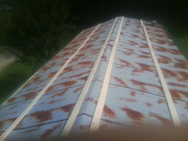 Rusted metal roof panels with new wood purlins before replacement — Storm Damage Roof Repair in Cambridge City by Roofing Brothers