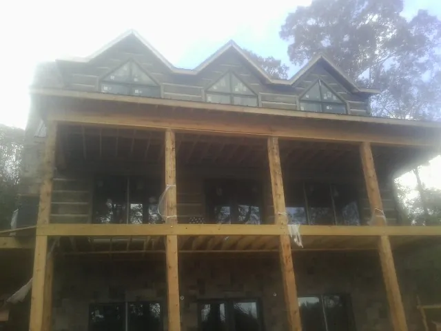 Dormers and porch framing on a large log home under construction — Roof Coating work by our crew in Cambridge City