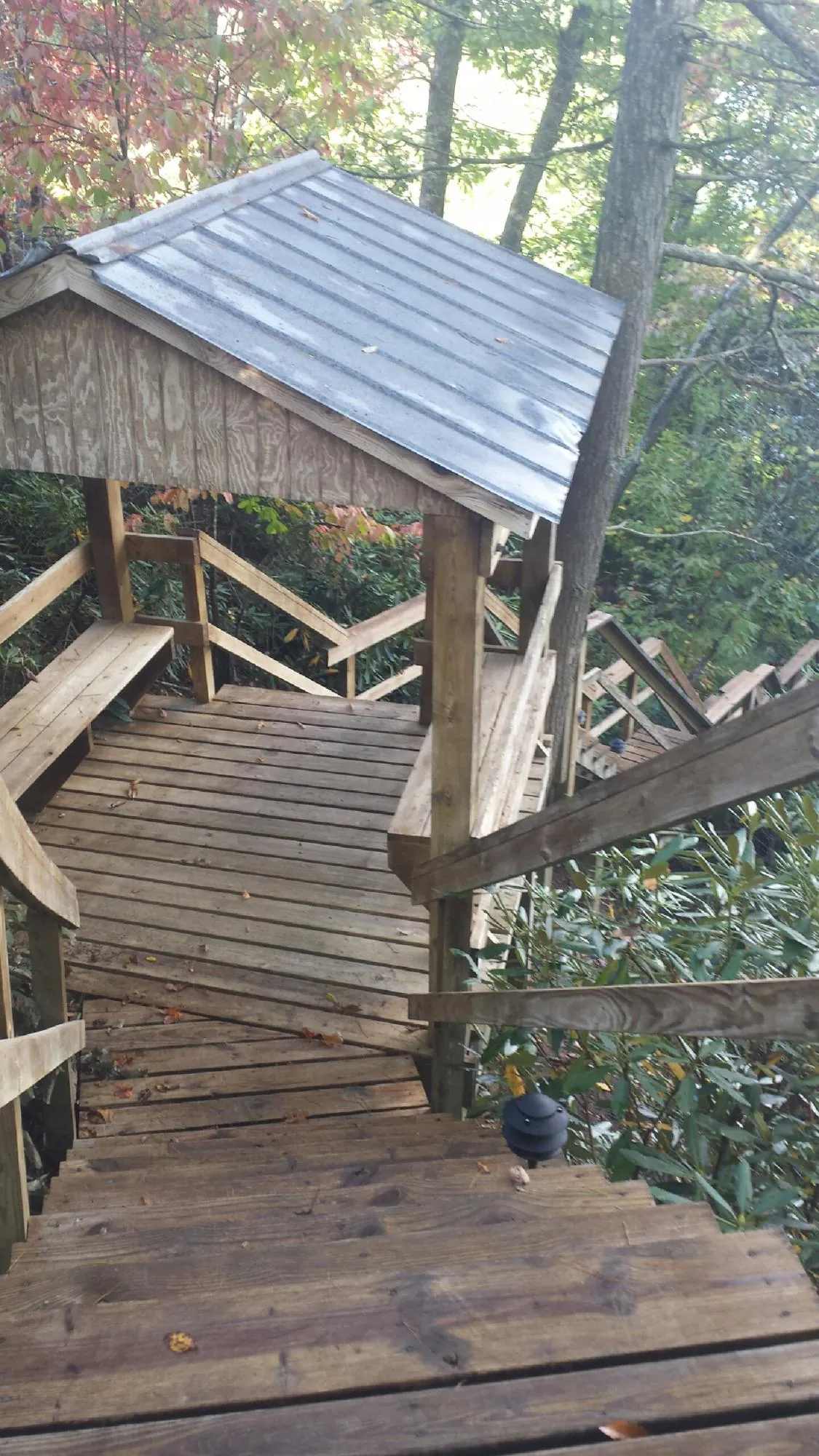 Metal roofed shelter over wooden steps on a wooded walkway — Skylight Repair & Installation work by our crew in Cambridge City